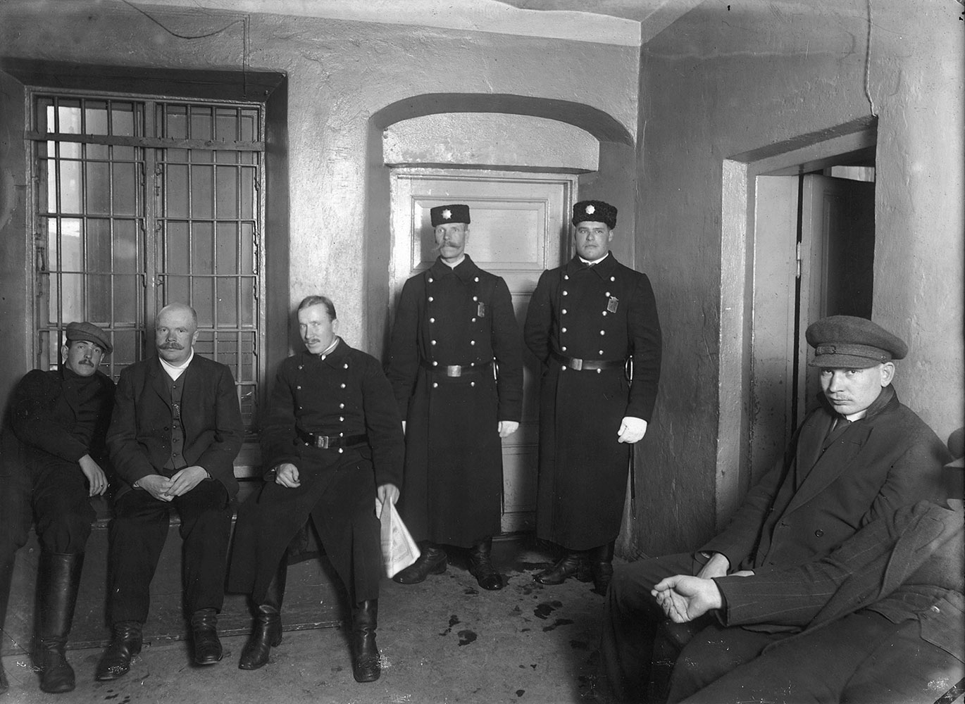 Poliisin päällystakit 1900-luvun alussa olivat malliltaan sotilaspäällystakkeja, joista käytettiin Suomessa nimityksiä mantteli ja sinelli. Takit olivat napitukseltaan yleensä kaksirivisiä ja materiaaliltaan paksua villakangasta. Väri vaihteli tummanharmaasta tummansiniseen asetuksesta riippuen. Helsingin poliisilaitoksen konstaapeleita ja heidän asiakkaitaan putkan eteisessä noin vuonna 1910.