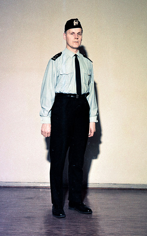 Vuonna 1958 tuli mahdolliseksi käyttää kesällä vaaleanharmaata kauluspaitaa kesätakin vaihtoehtona. Arvomerkit kiinnitettiin olkapäille tummansinisiin irto-olkaimiin. Kuvassa vanhempi konstaapeli.