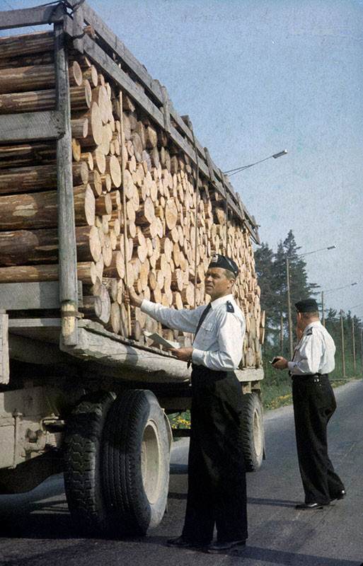 Maanteiden liikennevalvonnassa saatettiin kesäkuumalla riisua virkatakki, mutta valkoisesta paidastaan virkamies ei luopunut. Liikkuvan poliisin partio tarkastaa tukkirekan 1960-luvulla.